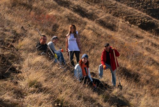 Five people sitting on the hill.